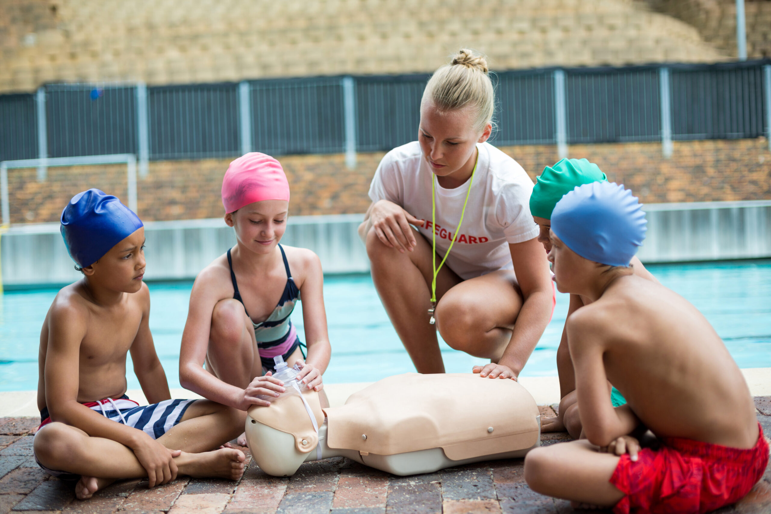 Lifeguard assisting children during rescue training